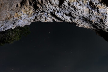 Night image of the starry sky seen from a viewpoint with a natural stone arch