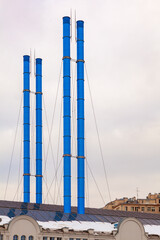 Picturesque blue factory chimneys against a cloudy sky