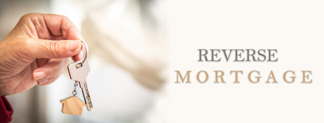 senior hand holding house key and keychain. investment and reverse mortgage concept