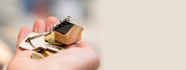 woman holding keys and money with little house keychain. concept of home loan, reverse mortgage,...