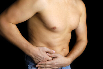 Naklejka premium Muscular man with side pain on black background. Person with naked torso suffering from kidney, stomach or pancreas inflammation