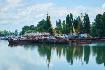 Naklejka premium A small industrial river port in the city. A river for small navigation.