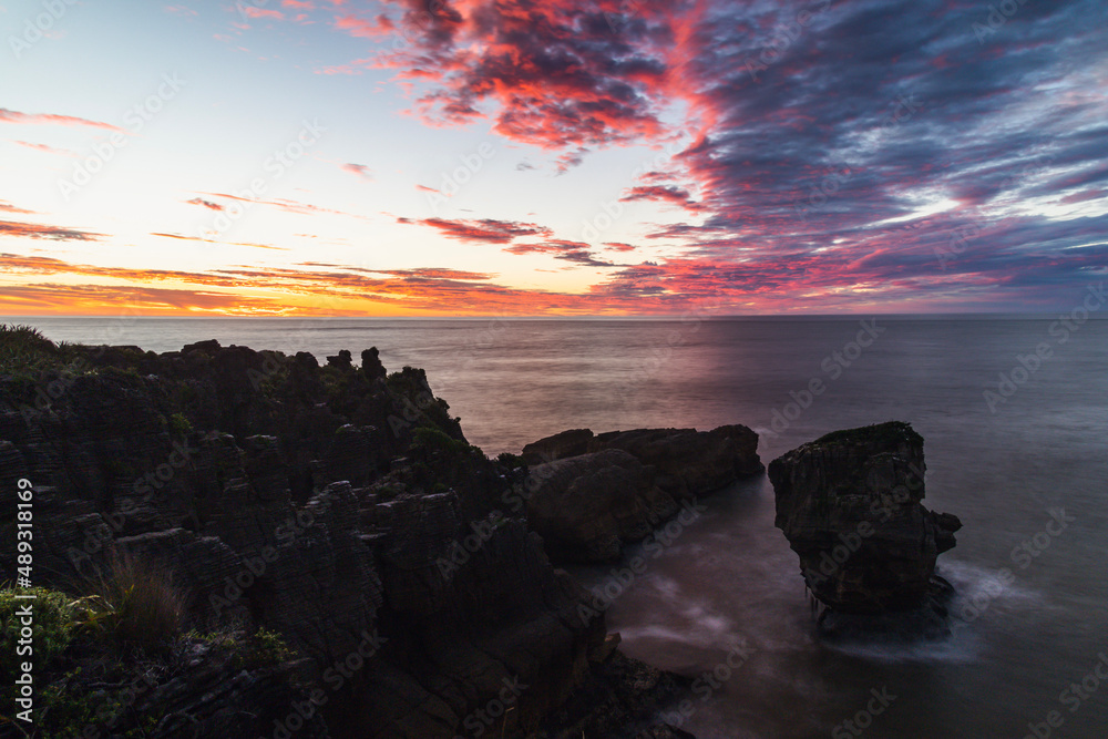 Wall mural Rocky shore line sunset over the sea