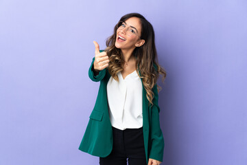 Young caucasian woman isolated on purple background with thumbs up because something good has happened