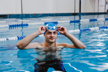 hispanic young man swimmer athlete wearing cap and goggles in a swimming training at the Pool in Mexico Latin America