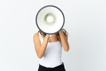 Young caucasian woman isolated on white background shouting through a megaphone to announce something