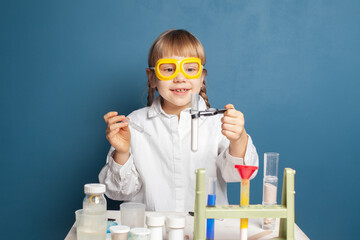 Happy little girl with flasks for chemistry. Science and education concept