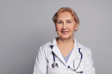 Doctor woman wearing white coat and stethoscope on shoulders looking at camera and smiling, counseling and therapy concept