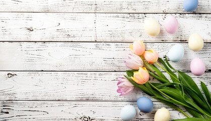 easter background with eggs and tulips on white wooden backdrop, top view flat lay
