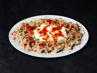 Plates of traditional Turkish food. Manti with tomato sauce.