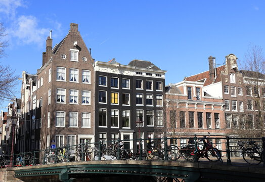 Amsterdam Singel Canal Street View with Corsgenbrug Bridge, Parked Bicyces and Buildings, Netherlands
