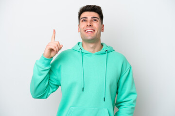 Young caucasian man isolated on white background pointing up and surprised