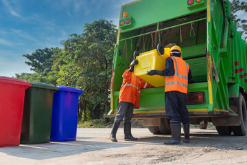 Teamwork garbage men working together on emptying dustbins for trash removal with truck loading waste and trash bin. Garbage collector.