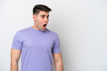 Fototapeta premium Young caucasian man isolated on white background doing surprise gesture while looking to the side