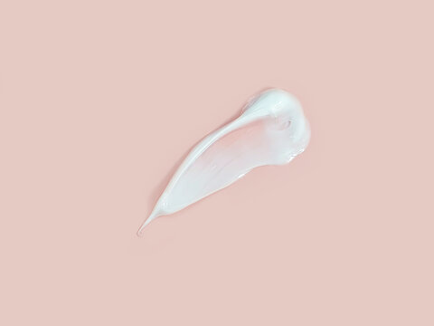 Big smear of moisturizer on pink background. Natural organic spa cosmetics concept, flatlay, top view.