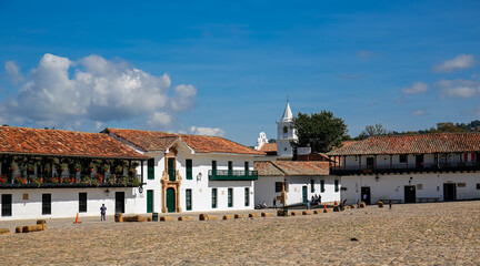 View of the northern corner Plaza Mayor on a sunny day, Monastery de Carmelitas Descalza in background, Villa de Leyva, Colombia