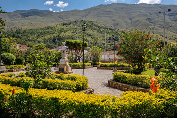 View from a park to traditional houses and mountains on a sunny day, Villa de Leyva, Colombia
