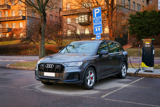 Audi Q7 60 TFSI e plug-in hybrid electric vehicle, PHEV, charging battery at seaside Charging Point. Finland. 
