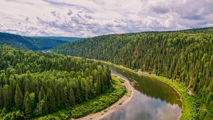 Fototapeta na wymiar Calm river in the mountains. Aerial view of the river, flowing in the Ural Mountains among the impenetrable forest.