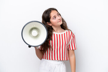 Little girl isolated on white background holding a megaphone and looking up while smiling