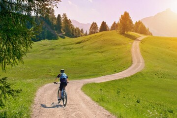 Biker riding scenic path in beautiful summer mountain scenery , Dolomites Italy, European Alps. - obrazy, fototapety, plakaty
