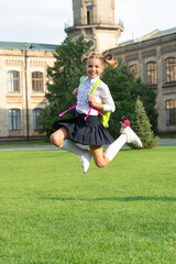 Happy energetic child in uniform back to school jumping for joy, September 1