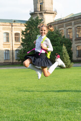 Fototapeta premium Happy energetic child in uniform back to school jumping for joy, September 1