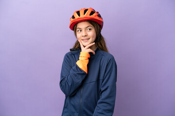 Little caucasian girl isolated on purple background thinking an idea while looking up