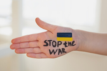 children's palm with the inscription stop war and the flag of ukraine, the actual concept of...