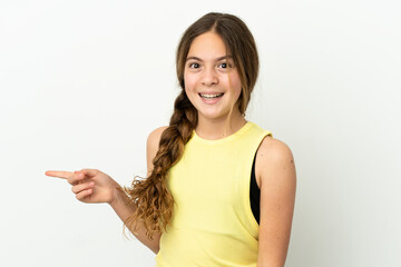 Little caucasian girl isolated on white background surprised and pointing finger to the side
