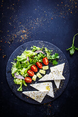 Fresh Greek salad - feta cheese, cherry tomatoes, cucumber and onion on wooden table
