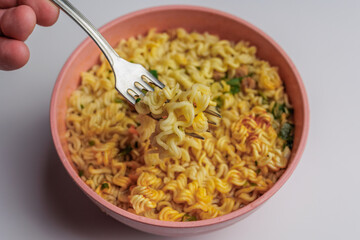 Instant noodles in a white plate top view. Fast food for lunch.