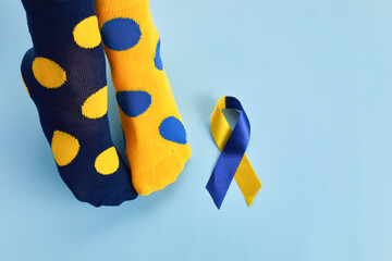 World Down syndrome day background. Down syndrome awareness concept. Socks and ribbon on blue...