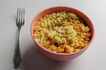 Instant noodles in a white plate top view. Fast food for lunch.