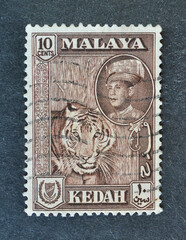 Cancelled postage stamp printed by Malaya, that shows tiger and portrait of Sultan Tengku...