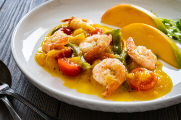 Prawns in mango sauce on wooden table
