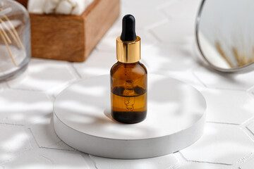Hyaluronic acid or collagen in a bottle, brown glass bottle. Сosmetic bottle, mockup on the podium on the tile. Spa set