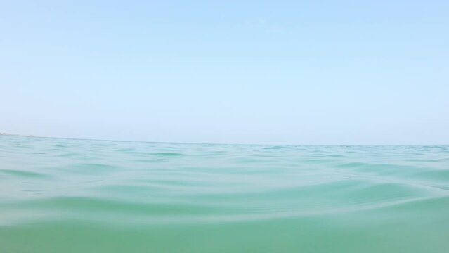 4K shot of calm sea water waves at of Shivrajpur Beach at Gujarat in India. Calm Beach water background. Sea water against the blue sky. 