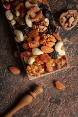 Mix of nuts and raisins on a brown rustic background.