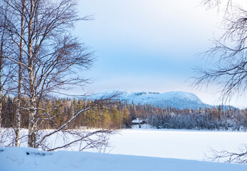Snowy plain, frozen lake and winter landscape. Sunrise over the mountain.
