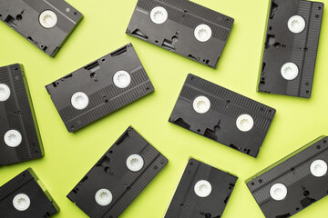 Pattern made with old tape VHS cassette on color background, top view