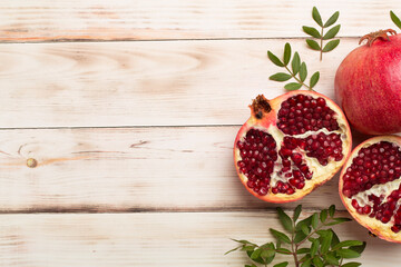 Fresh juicy pomegranate on white wooden background, top view
