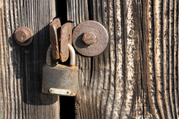 Old rusty lock on a wooden door.
