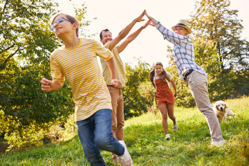 Fototapeta premium Two children run through gate formed from hands