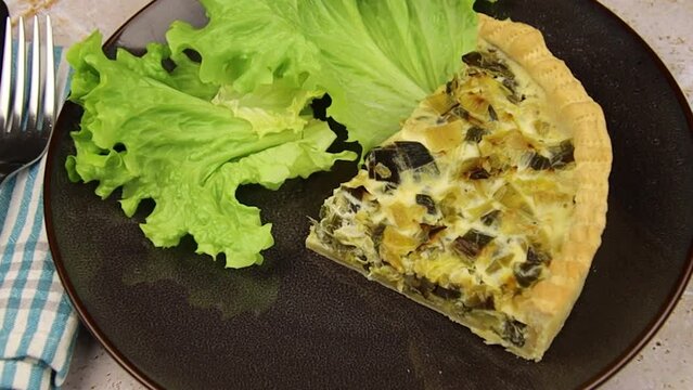slice of leek quiche on a plate with salad