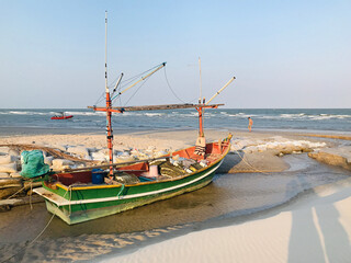 A local fishing boat moored on the beach of Hua Hin in Thailand.