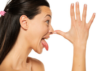 profile of a woman who is mocking with the palm of on the nose