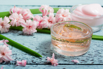 cosmetic creams with pink hyacinth flowers, on old cracked blue table