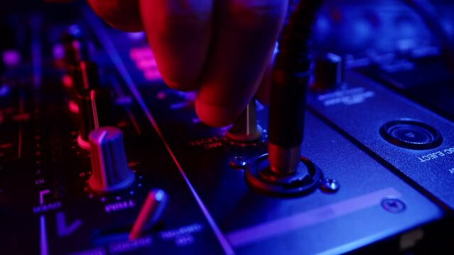 Macro of digital mixing console with plug inserted on background of hands, tuning fader. Concept modern musical accompaniment parties