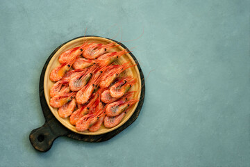 Shrimps on a white plate, against the background